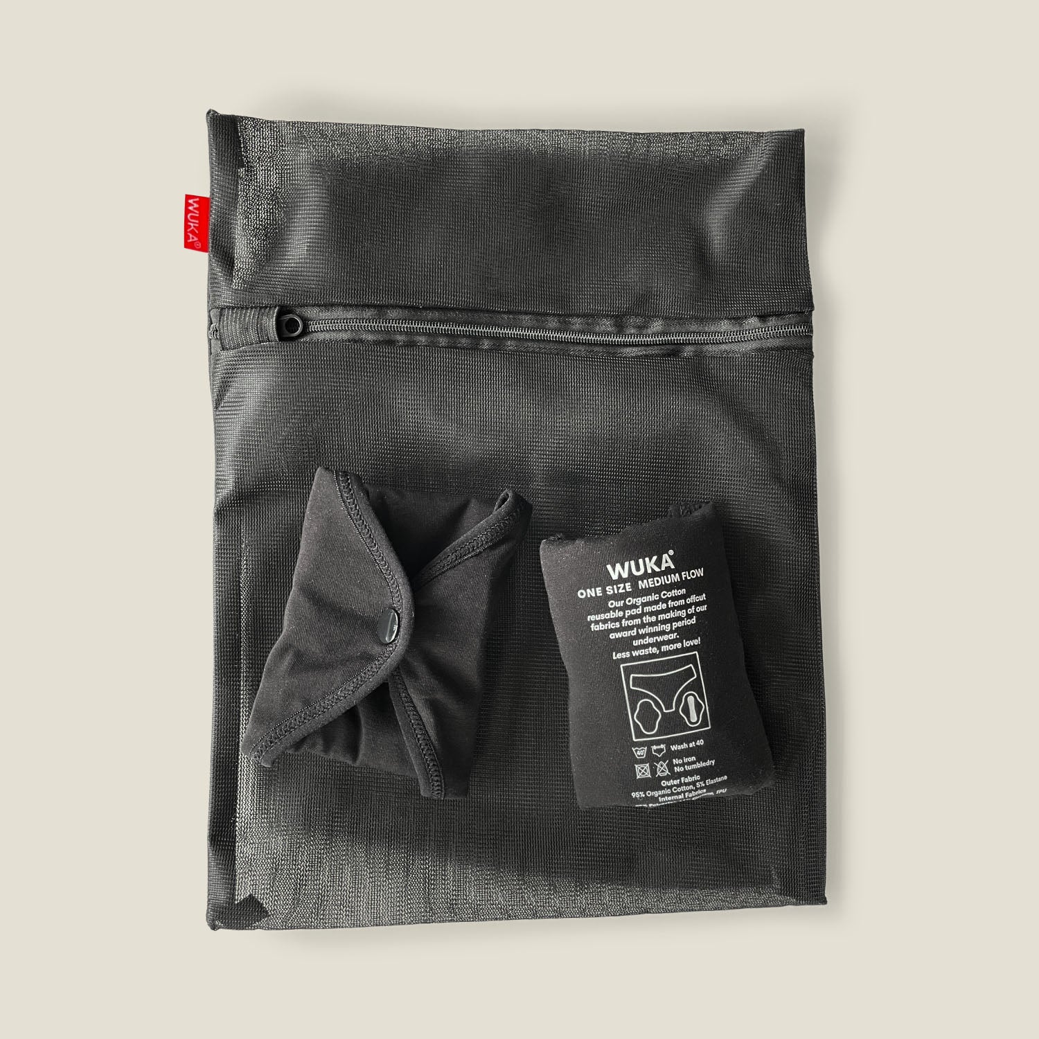 WUKA mesh laundry bag featuring two reusable period pads folded outside the bag, highlighting its capacity and functional design.