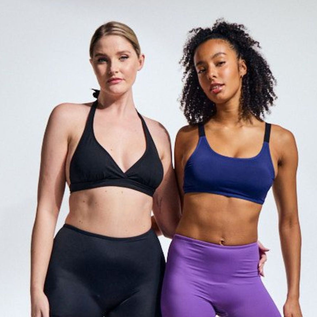 Two women stand confidently in activewear, showcasing comfort and body diversity—empowering period protection designed for movement, strength, and self-assurance.