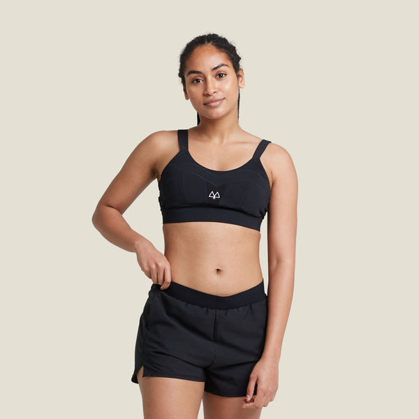 Model wearing WUKA Period Sports Shorts in black, designed for medium flow. Breathable, high-performance activewear for periods with built-in leak-proof protection.