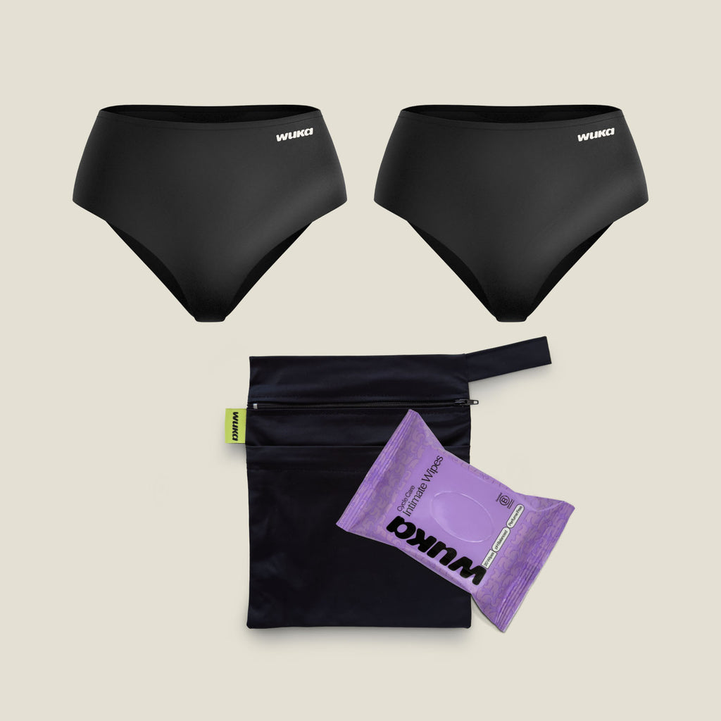 Flat lay of WUKA Period Go Bag bundle, featuring two black Stretch™ Heavy Flow period pants, a double-pocket changing bag, and a pack of biodegradable intimate wipes
