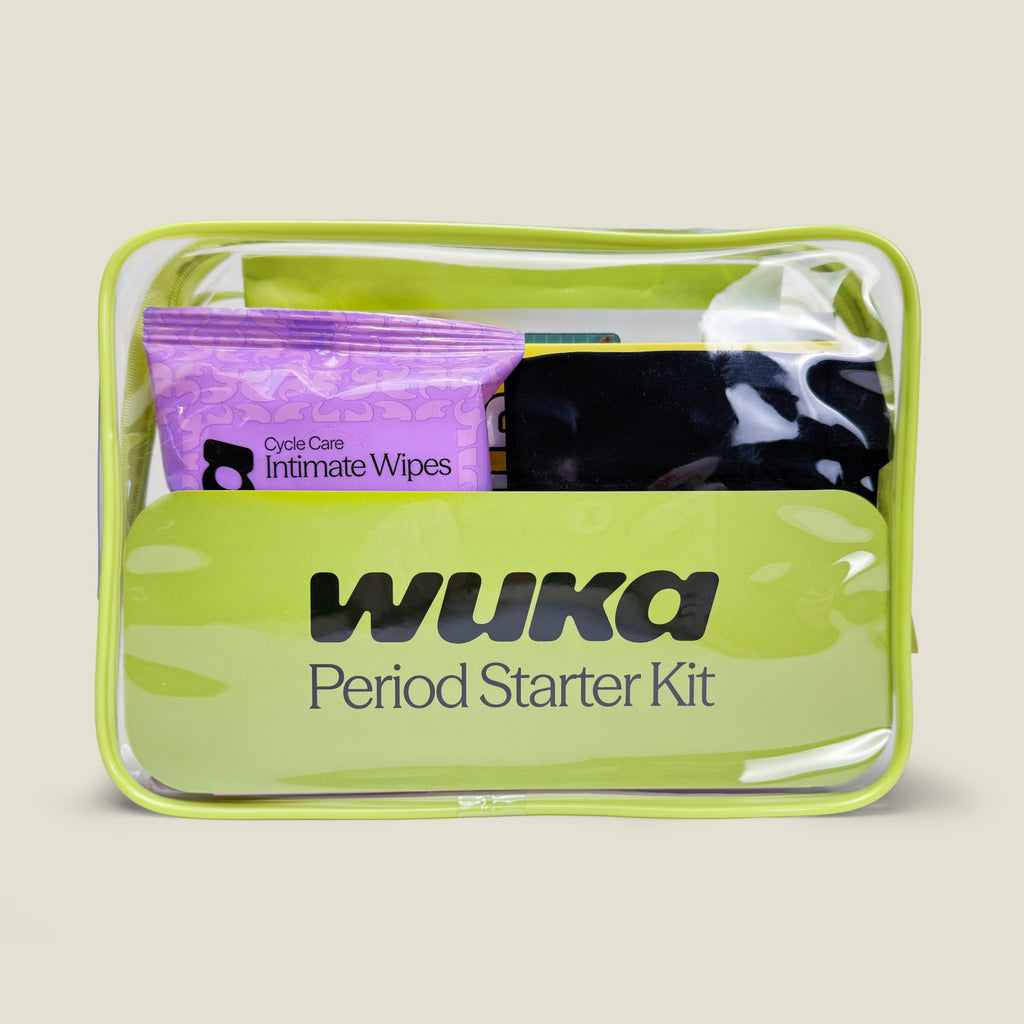 Front view of WUKA Period Starter Kit in a clear green zip pouch, showing included Cycle Care Intimate Wipes, black Stretch™ period pants, and other essentials for first periods.