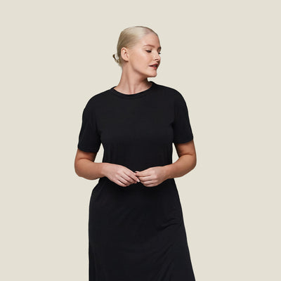 Woman modeling WUKA black T-shirt dress, menopause sleepwear with soft, stretchy jersey fabric and temperature-regulating properties.
