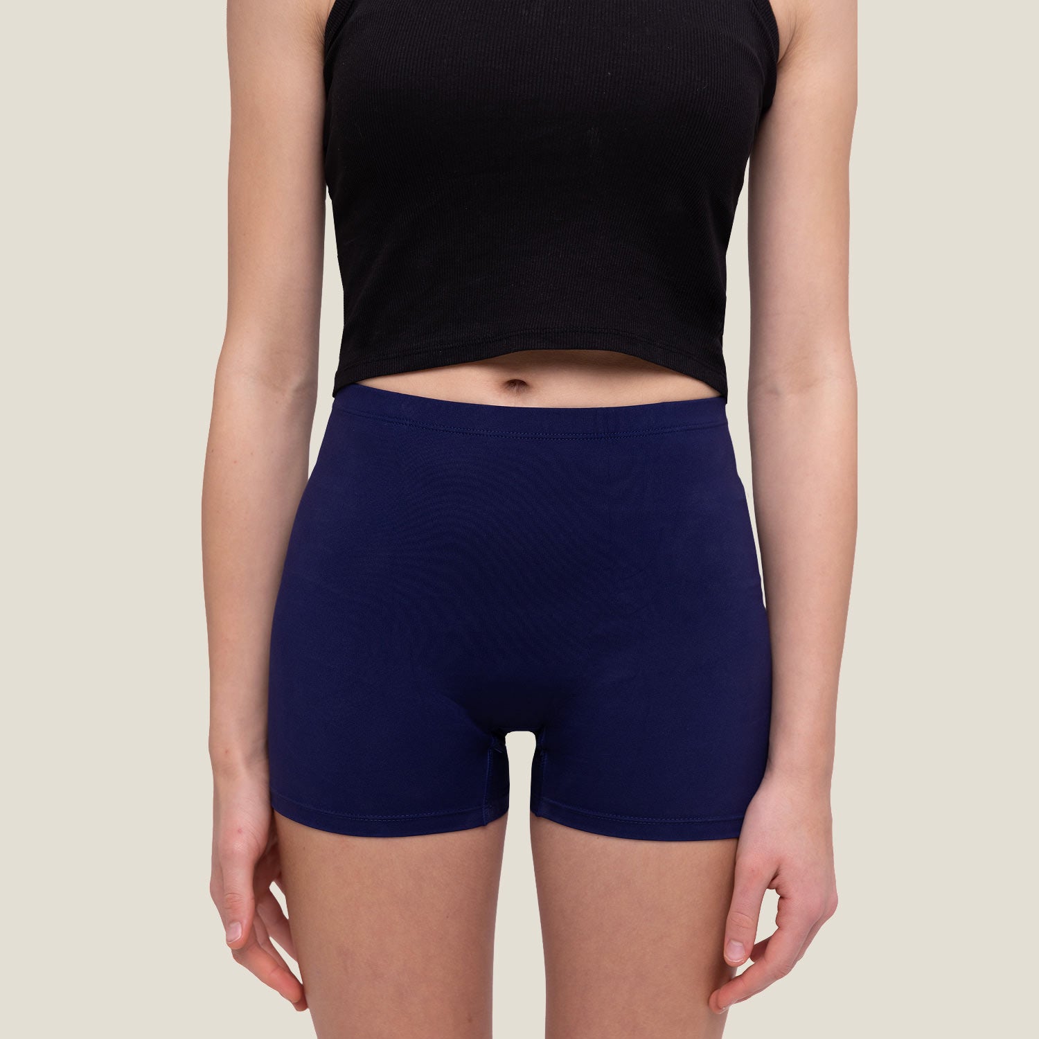 Female wearing navy WUKA swim blue shorts and a black top